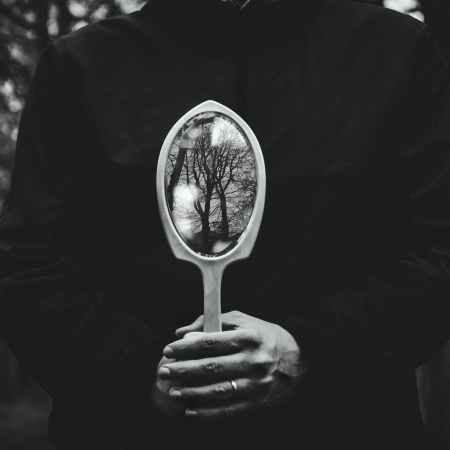person holding hand mirror | gothic noir